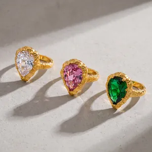 Vista detallada de anillos de circón en forma de gota con acabado dorado martillado