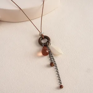 Detailed view of a vintage boho necklace featuring a resin drop and wooden ring