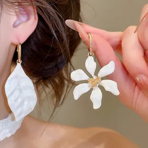Elegantes pendientes de aro asimétricos de flor y hoja en esmalte blanco y acabado oro