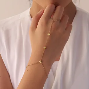 Vue détaillée d'un bracelet bague élégant en acier doré avec motifs de cœurs