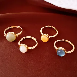 Detalle de anillos ajustables chapados en oro de 18k con piedras redondas de colores