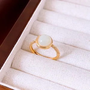 Primer plano de un elegante anillo abierto bañado en oro de 18k con piedra blanca