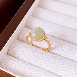 Detalle de anillo ajustable chapado en oro de 18k con una piedra redonda verde pálido