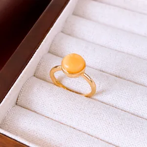 Vista macro detallada de un anillo abierto chapado en oro de 18k con piedra amarilla