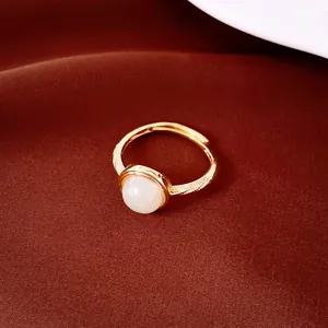 Primer plano de un elegante anillo abierto chapado en oro de 18k con piedra blanca