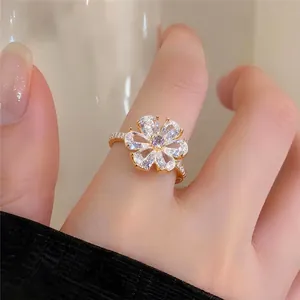 Eleganter vergoldeter offener Ring mit einer funkelnden Zirkonia-Blume und lila Mittelstein.