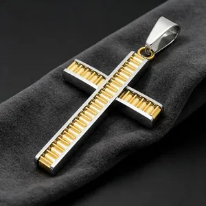 Detalle de primer plano de un colgante de cruz en acero de titanio dorado y plateado.