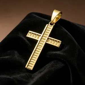 Vista macro de un colgante de cruz de acero de titanio dorado con ranuras texturizadas