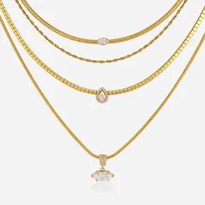 Close-up of four layered golden stainless steel necklaces with sparkling crystal pendants