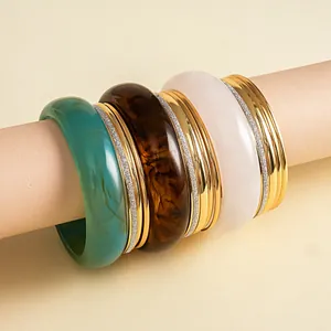 Close-up van vintage hars en metalen armbanden set met schildpad en groenblauwe patronen