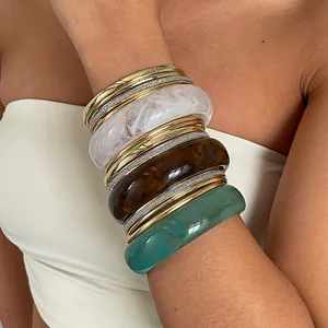 Gedetailleerd overzicht van een vintage metalen en gemarmerde hars armbandenset op model