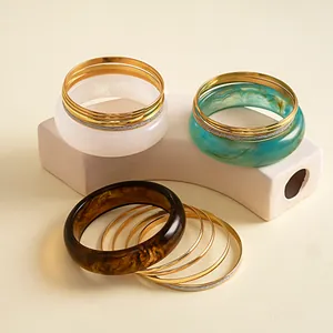 Vintage retro set van vijf armbanden met gemarmerd hars en dunne goudkleurige metalen ringen
