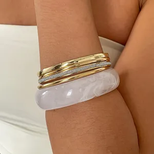 Detailopname van 5-delige retro metalen en gemarmerde hars cirkelvormige armbandenset