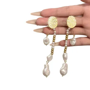 Boucles d'oreilles élégantes en perles baroques irrégulières avec disques dorés.
