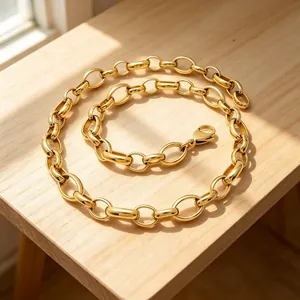 Vue détaillée d'un collier à maillons en acier inoxydable doré sur un support en bois.
