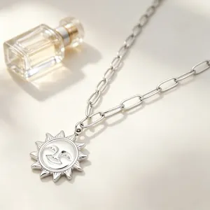 Gros plan d'un pendentif soleil vintage sur un collier à maillons argentés