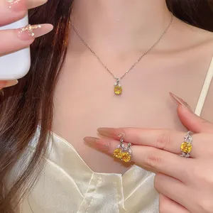 Detailansicht eines gelben Zirkonia-Blumenschmucksets mit Halskette, Ohrringen und einem Ring