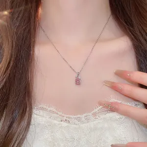 Detailansicht einer eleganten Halskette mit rosa Zirkon-Blumenanhänger am Hals des Modells.