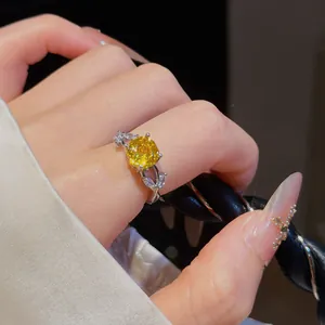 Detailaufnahme eines Silberrings mit gelbem Zirkonia und elegantem Blattdesign an der Seite