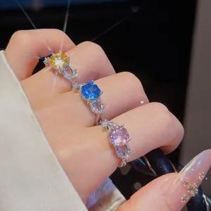 Detailaufnahme eleganter Blumenringe mit leuchtend gelben, blauen und lila Zirkonia Steinen.