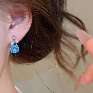 Detailansicht eines eleganten blauen Zirkon-Blumen-Ohrhängers im koreanischen Stil.
