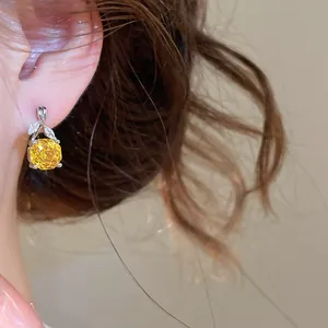 Nahaufnahme eines eleganten Silberohrrings mit gelbem Zirkonia und Blattverzierung