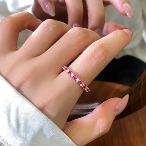 Détail d'une bague d'éternité en or rose sertie de zircons cubiques roses et blancs