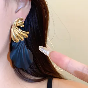 Elegante Ohrstecker aus Harz in Gold und Schwarz mit Muschelform in einer Detailansicht