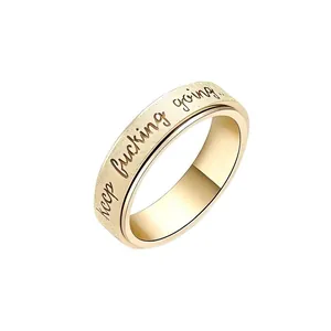 Macro view of gold plated stainless steel spinner ring with cursive engraving details