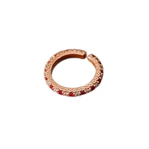 Bague ouverte en or rose avec zircons rouges et détails de bordure dentelée.