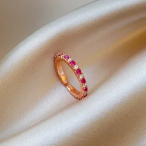 Détail d'une bague ajustable en or rose sertie de zircons sur fond de soie douce