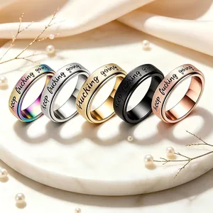Close-up detail of five stainless steel spinner rings with engraved motivational quote