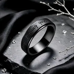 Macro view of black rotatable stainless steel ring with keep fucking going engraving