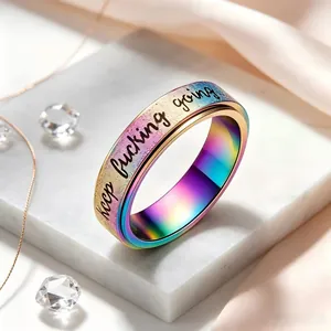 Close-up of rotatable stainless steel ring with keep fucking going engraving