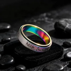 Close-up of rotatable stainless steel ring with rainbow inner band and engraving