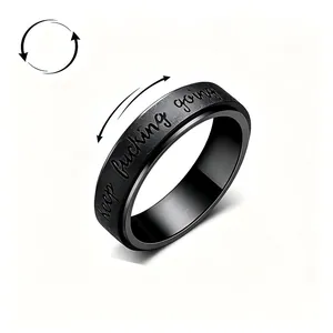 Close-up detail of black stainless steel spinner ring with Keep Fucking Going text