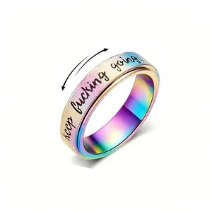 Detail of rotating stainless steel ring with rainbow finish and motivational quote