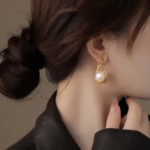 Vue détaillée de boucles d'oreilles élégantes en maille dorée 18k avec une perle texturée.