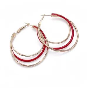 Élégantes créoles triples dorées avec détails en émail rouge pour un look chic et moderne.