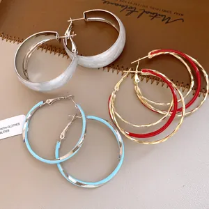 Vue détaillée de créoles torsadées avec des finitions en émail coloré