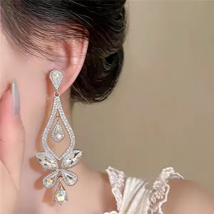 Nahaufnahme von eleganten glitzernden Strass-Kronleuchter-Ohrringen an einem Modell
