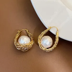 Gros plan de boucles d'oreilles plaquées or 18 carats avec perles baroques