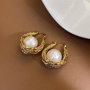 Gros plan détaillé sur des boucles d'oreilles créoles vintage plaquées or 18 carats avec perle.
