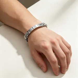 Detailed view of men's Byzantine titanium steel bracelet on wrist with engravable plate