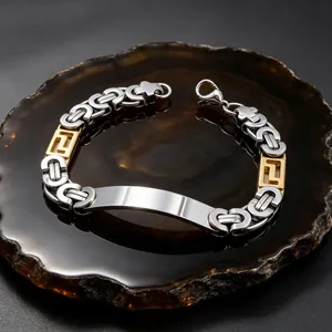 Close-up detail of a silver and gold Byzantine stainless steel bracelet with engravable plate.