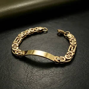 Macro detail view of a men's gold Byzantine titanium steel chain bracelet with engravable plate