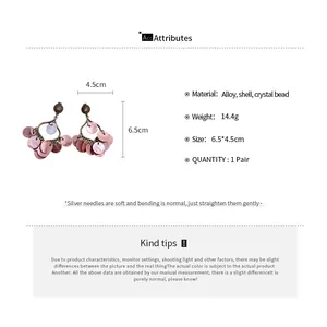 Detail view of shell tassel earrings with size dimensions and material info