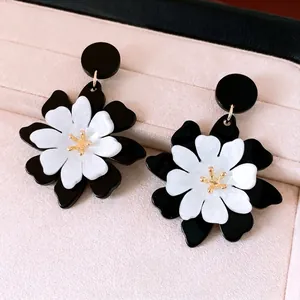 Boucles d'oreilles fleurs en acrylique noir et blanc avec détails de pistils dorés