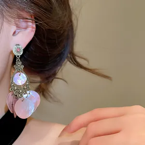 Detail of vintage bohemian earrings featuring iridescent pink shell tassels and crystal.