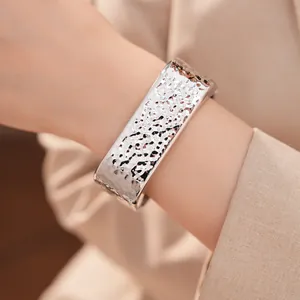 Primer plano detallado de la textura martillada de un brazalete rectangular plateado